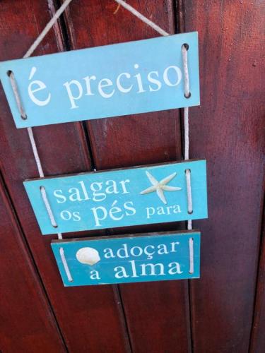 two signs hanging on a wooden wall at FLAT / APARTAMENTO NA PRAIA DO FORTE in Cabo Frio