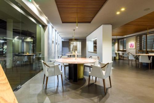 a dining room with a table and white chairs at Hotel Royal Paestum in Paestum