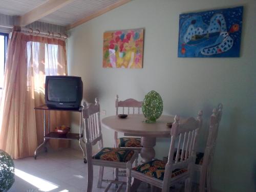 a dining room with a table and a tv at Anna Koralli Studios in Laganas