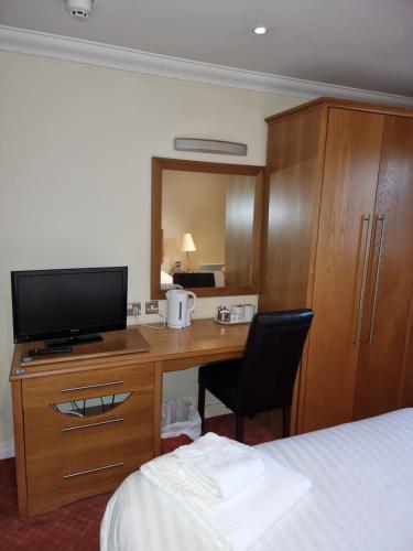 a bedroom with a bed and a desk at Kegworth Hotel & Conference Centre in Castle Donington
