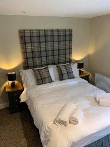 a bedroom with a white bed with two towels on it at The Dukes Head in Armathwaite
