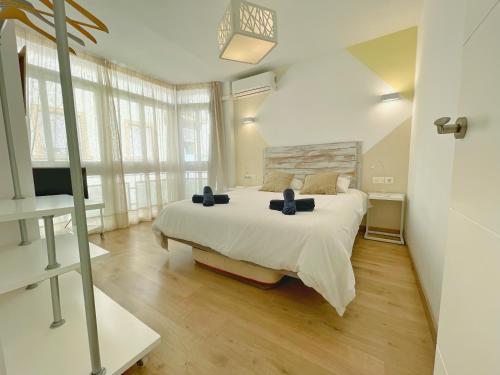 a bedroom with a large bed and a large window at Apartamento Soho Malaga in Málaga