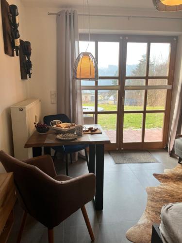 a room with a table and chairs and a window at Appartement Gabriela ACHTUNG nur Feriengäste willkommen,es ist keine Arbeiterunterkunft in Obernzell
