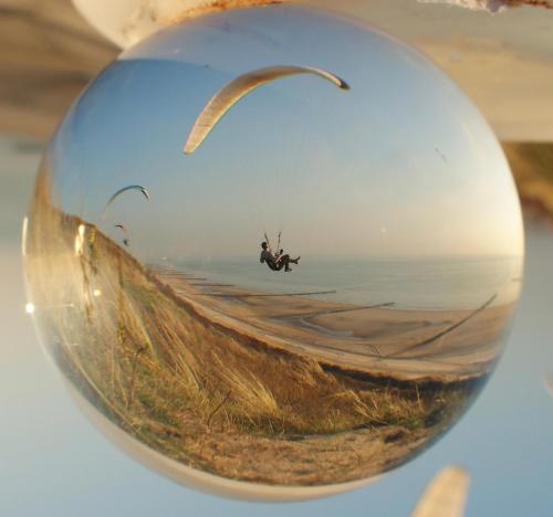 a glass ball with a person riding a paraglider at Klinket Zoutelande in Zoutelande