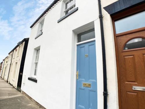 a house with a blue door and a wooden door at Cosy 2 bedroom cottage in Scarborough's Old Town in Scarborough
