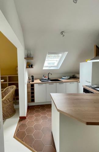 d'une cuisine avec des placards blancs et une lucarne. dans l'établissement Superbe appartement 4 personnes Le Pouliguen avec vue magnifique sur le port et la mer, au Pouliguen