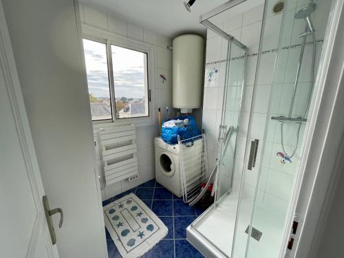 een badkamer met een douche en een wasmachine bij Superbe appartement 4 personnes Le Pouliguen avec vue magnifique sur le port et la mer in Le Pouliguen