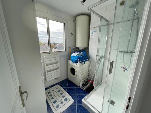a bathroom with a shower and a washing machine at Superbe appartement 4 personnes Le Pouliguen avec vue magnifique sur le port et la mer in Le Pouliguen