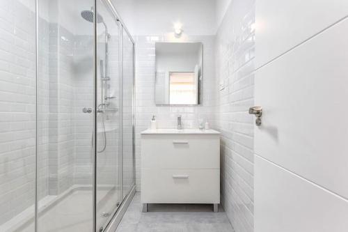 a white bathroom with a sink and a shower at Apartamento Soho Malaga in Málaga