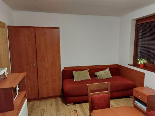 a living room with a red couch and a window at Chata Salma Jeseníky in Dolní Moravice