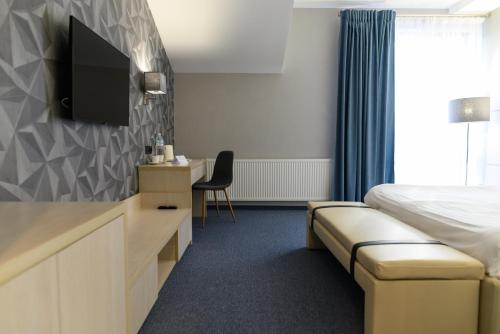 a hotel room with a bed and a flat screen tv at Hotel Zefir in Drohobytsch