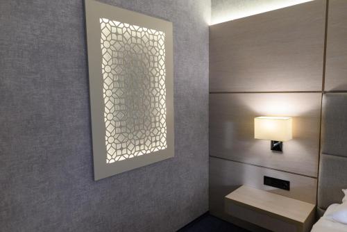 a room with a bed and a lamp on a wall at Hotel Zefir in Drohobytsch