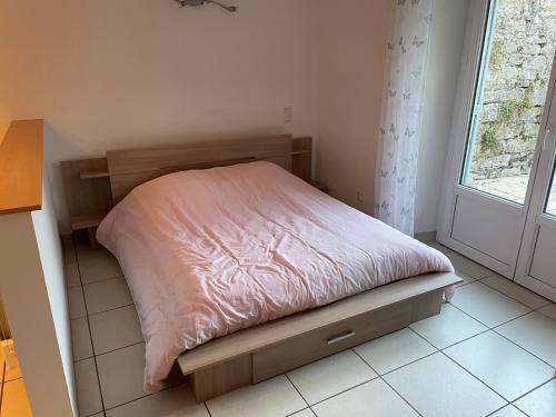 uma pequena cama num pequeno quarto com uma janela em Studio 4 couchages avec terrasse proximité du lac em Clairvaux-les-Lacs