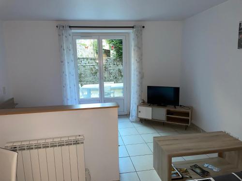 uma sala de estar com uma televisão e uma mesa em Studio 4 couchages avec terrasse proximité du lac em Clairvaux-les-Lacs