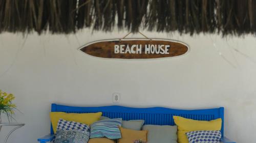 a beach house sign hanging above a blue couch at Estrela Azul Guest House Búzios in Búzios