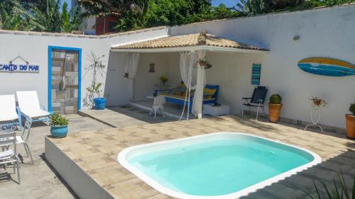 a swimming pool in a patio with a table and chairs at Estrela Azul Guest House Búzios in Búzios