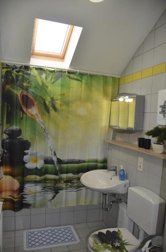 a bathroom with a sink and a shower curtain at Ferienwohnung Wildgatter in Grafenwiesen
