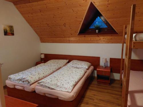 2 camas en una habitación pequeña con ventana en Chata Salma Jeseníky, en Dolní Moravice