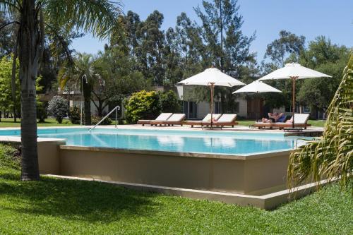 uma piscina com espreguiçadeiras e guarda-sóis em Noha Casa de Campo em Colón