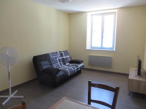 a living room with a couch and a window at appartement 4 à 6 couchages in Clairvaux-les-Lacs