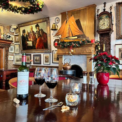 a bottle of wine sitting on a table with wine glasses at Hotel & Restaurant De Fortuna in Edam