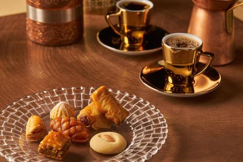 a plate of pastries on a table with two cups of coffee at Moon Palace The Grand Cancun All Inclusive in Cancún