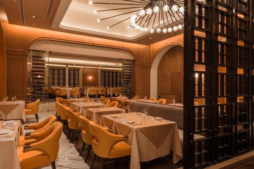 a restaurant with tables and chairs and a chandelier at Moon Palace The Grand Cancun All Inclusive in Cancún