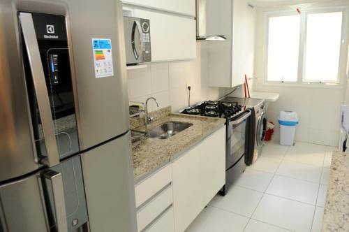 a kitchen with a sink and a refrigerator at ACONCHEGO E BEM ESTAR in Brasilia