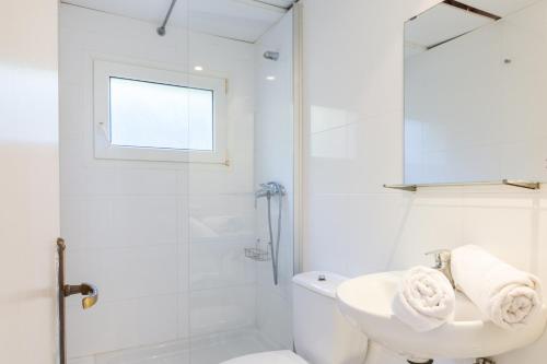 a white bathroom with a sink and a shower at Anc 05 - Llafranc in Llafranc