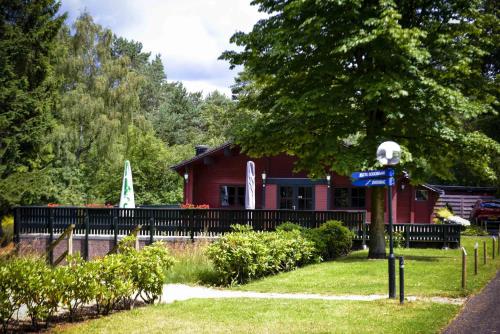 a red house with a boat in the yard at Fletcher Hotel Restaurant De Wipselberg-Veluwe in Beekbergen