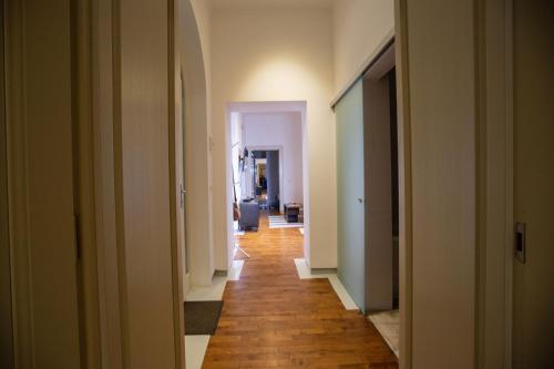 a hallway with a long corridor with white walls and wooden floors at Alessia Apartment in the Old Town in Timişoara