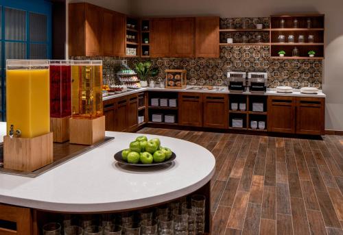 a kitchen with a table with a bowl of fruit on it at Hyatt House Tampa Downtown in Tampa