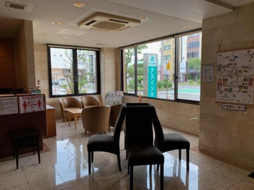 a waiting room with chairs and a table in a building at AZ Inn Obu in Obu
