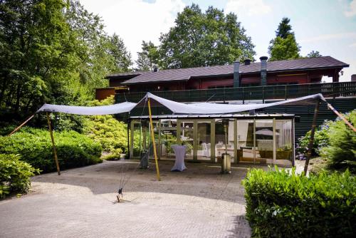 a house with a tent in front of it at Fletcher Hotel Restaurant De Wipselberg-Veluwe in Beekbergen