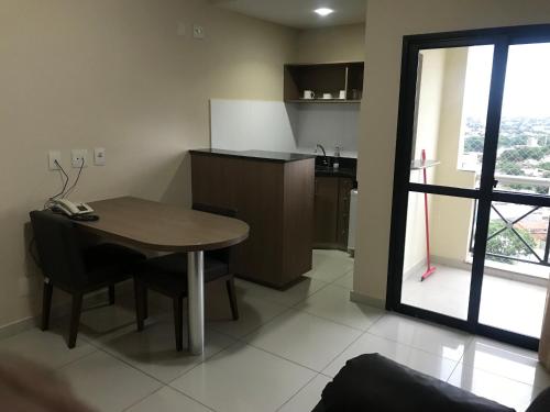 a kitchen with a wooden table and a kitchen with a window at Crystal Place in Goiânia
