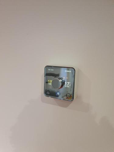 a camera is hanging on a white wall at Modern house close to Glasgow Green in Glasgow