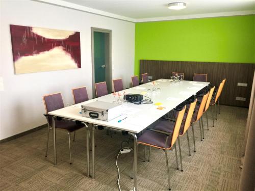a conference room with a long table and chairs at Hotel Ambiente Walldorf in Walldorf
