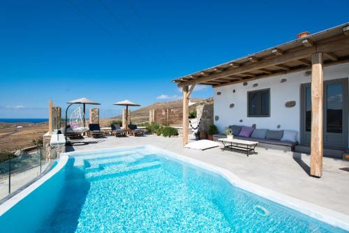 a villa with a swimming pool and a house at Mykonos Village in Ano Mera