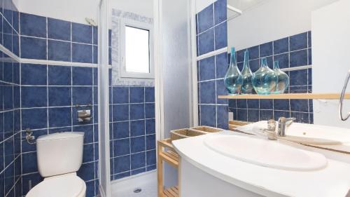 ein blau gefliestes Badezimmer mit Toilette und Waschbecken in der Unterkunft CB K-2 - Calella de Palafrugell in Calella de Palafrugell