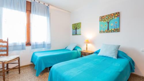 een slaapkamer met twee bedden en een stoel en een raam bij CV - Calella de Palafrugell in Calella de Palafrugell