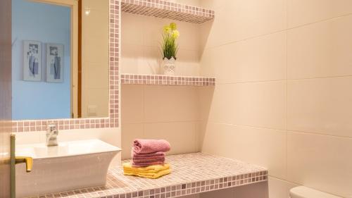 een witte badkamer met een wastafel en een spiegel bij CV - Calella de Palafrugell in Calella de Palafrugell