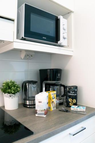 a microwave sitting on top of a kitchen counter at Heart of Oulu studio Parking in Oulu