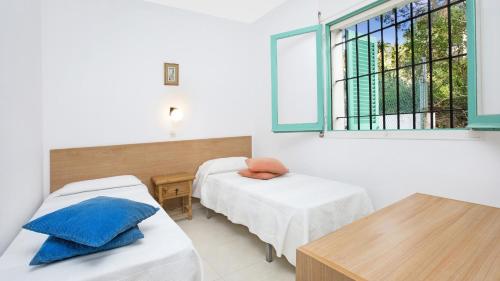 Zimmer mit 2 Betten, einem Tisch und einem Fenster in der Unterkunft Ger 3 - Llafranc in Llafranc