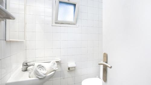 ein Badezimmer mit einem Waschbecken und einem WC mit Handtüchern in der Unterkunft Ger 3 - Llafranc in Llafranc