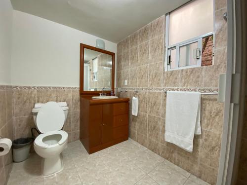 La salle de bains est pourvue de toilettes, d'un lavabo et d'un miroir. dans l'établissement Grupo Kings Suites - Bosques de Duraznos 78, à Mexico
