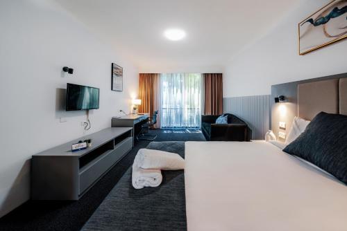 a hotel room with a bed and a living room at The Select Inn Penrith in Penrith