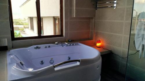 uma casa de banho com uma banheira, uma janela e uma vela em Hotel Casa Sakiwa em Machachi