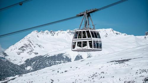 a ski lift in front of a snow covered mountain at The little refuge of La Plagne (French Alps) in Plagne 1800