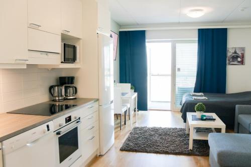 a kitchen and a living room with a couch at City center brand new studio, parking in Oulu