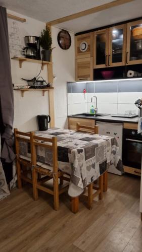 une cuisine avec une table, des chaises et un évier dans l'établissement The little refuge of La Plagne (French Alps), à Plagne 1800